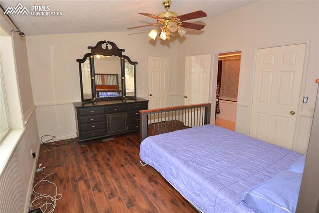 5720 Sayres Road Colorado Springs, CO 80927 - Photo 10 of 31 Private master bedroom suite with wood plank floors, large walk in closet, and attached bath.