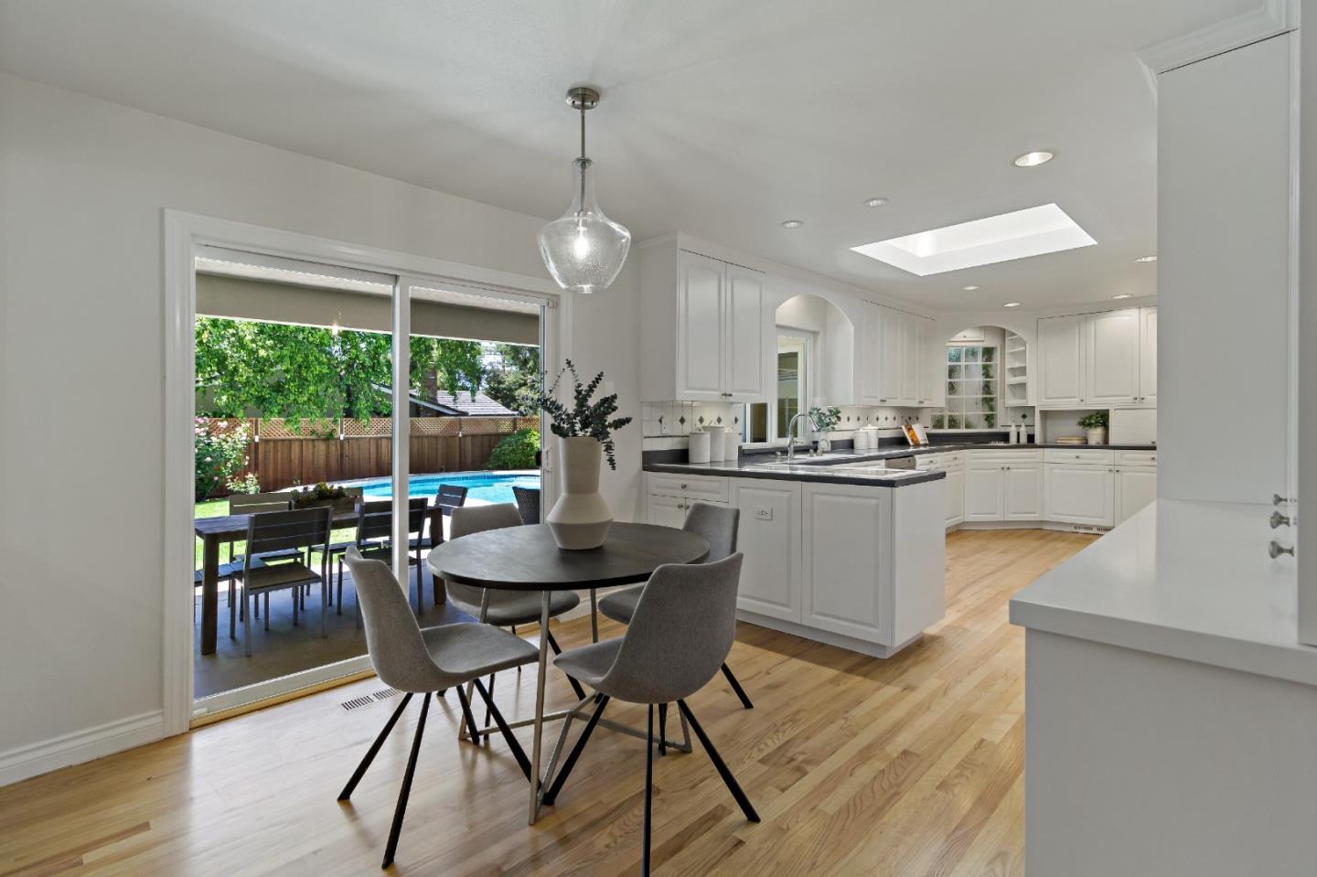 869 Terrace Drive Los Altos, CA 94024 - Photo 21 of 86 a kitchen with stainless steel appliances kitchen island granite countertop a dining table chairs and white cabinets