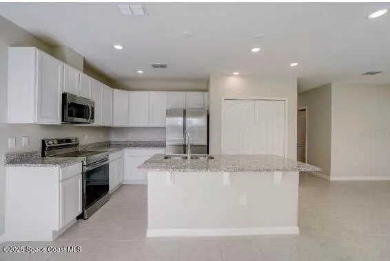 a kitchen with stainless steel appliances a refrigerator and microwave
