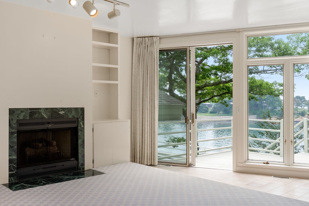 23 Ocean Street Manchester, MA 01944 - Photo 19 of 36 a living room with a fireplace and a large window