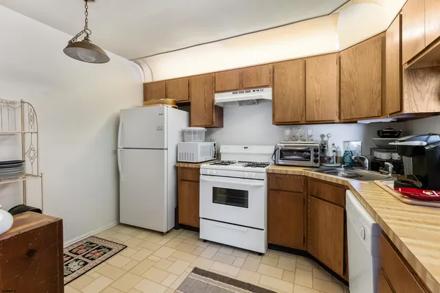 a kitchen with a sink a refrigerator and cabinets