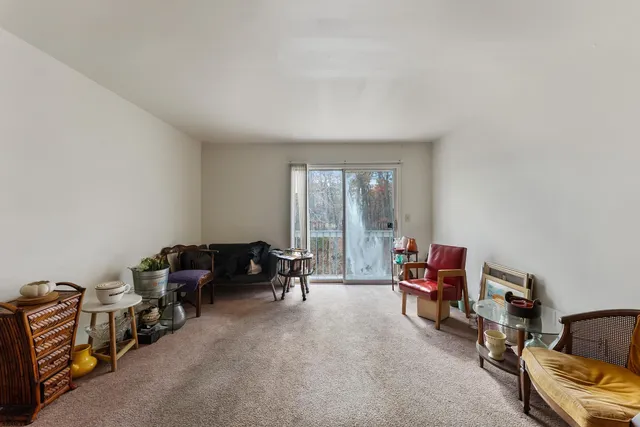 a living room with furniture a flat screen tv and a window