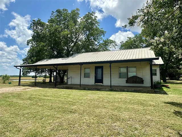 a view of a house with a yard and sitting area