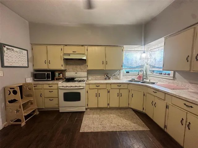 a kitchen with sink cabinets and wooden floor
