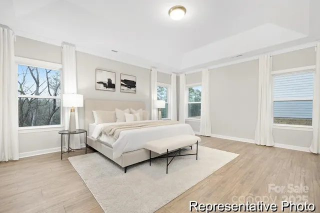 a spacious bedroom with a white bed and a window