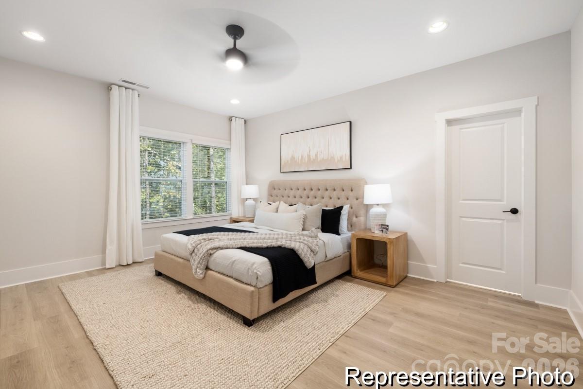 105 West Rice Planters Way, Unit 1P Statesville, NC 28625 - Photo 22 of 41 a spacious bedroom with a large bed and a chandelier