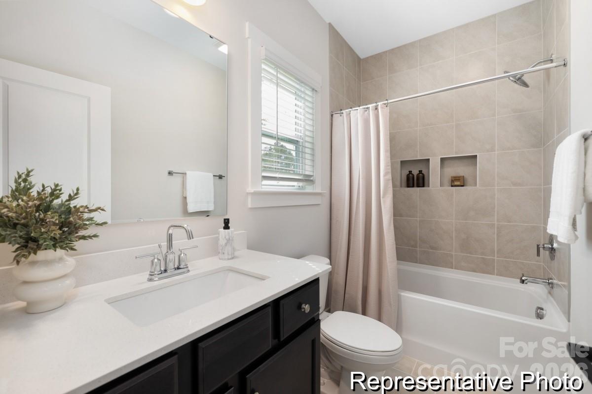 105 West Rice Planters Way, Unit 1P Statesville, NC 28625 - Photo 35 of 41 a bathroom with a sink a toilet a mirror a vanity and shower