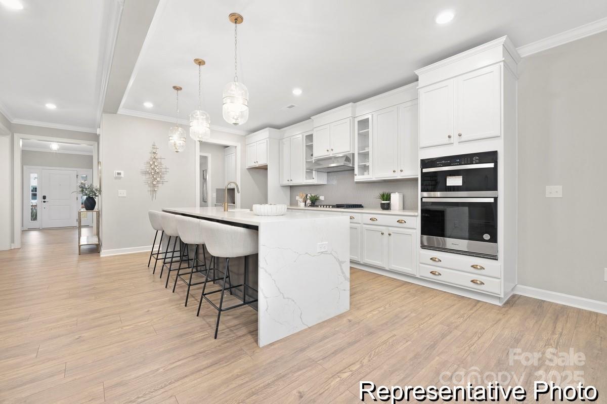105 West Rice Planters Way, Unit 1P Statesville, NC 28625 - Photo 4 of 38 a kitchen with stainless steel appliances kitchen island granite countertop a stove top oven a sink a counter top space and cabinets