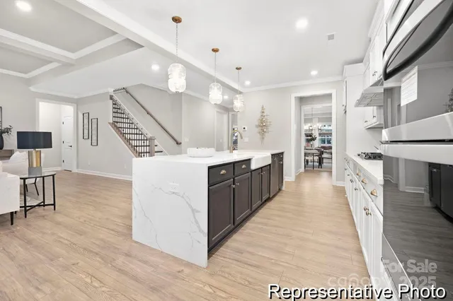 a large white kitchen with wooden floor and a sink
