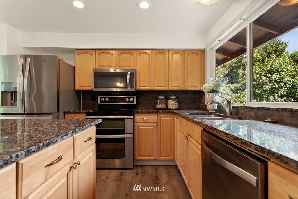 5011 Northeast 24th Street Renton, WA 98059 - Photo 14 of 34 a kitchen with stainless steel appliances granite countertop a stove a sink and a microwave
