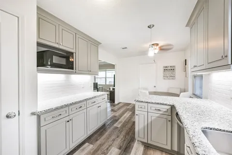 a kitchen with granite countertop cabinets stainless steel appliances and a sink