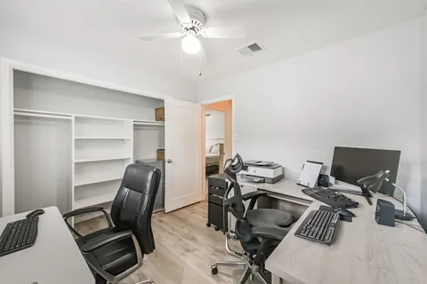 a view of a workspace with furniture and a ceiling fan