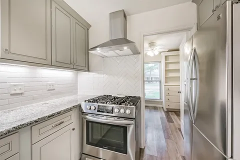 a kitchen with stainless steel appliances granite countertop a stove and a refrigerator