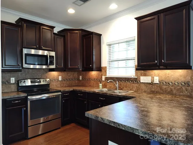 a kitchen with granite countertop wooden cabinets and a granite counter top