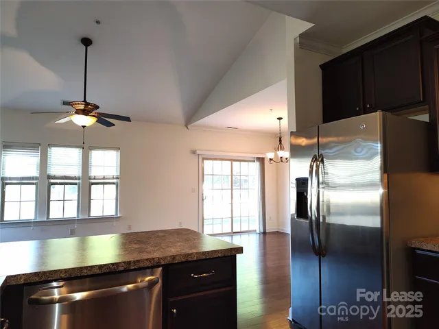a kitchen with stainless steel appliances granite countertop a sink a stove and a refrigerator