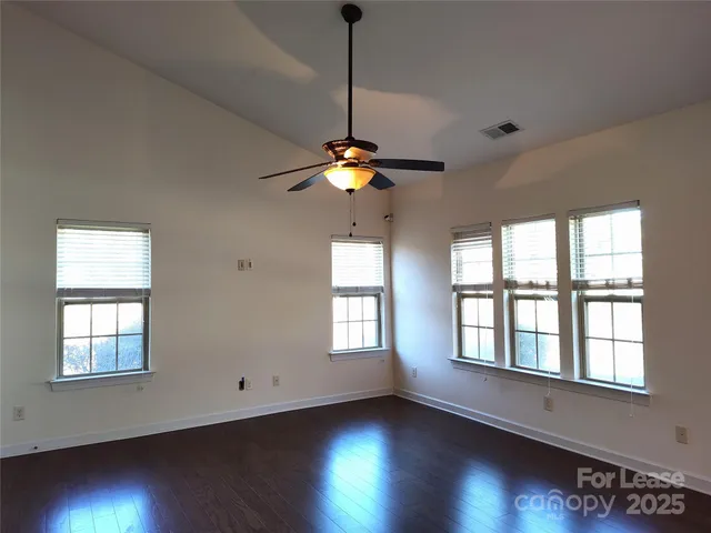 a view of wooden floor and a chandelier fan in a room