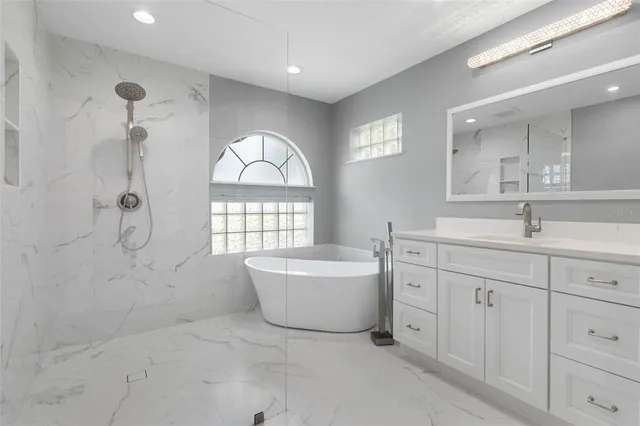 a bathroom with a sink mirror and a bathtub