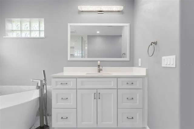 a bathroom with a sink a bathtub and window