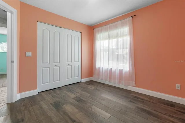 a view of a hallway with wooden floor and windows