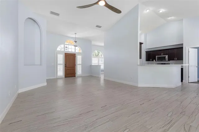 an empty room with wooden floor and windows