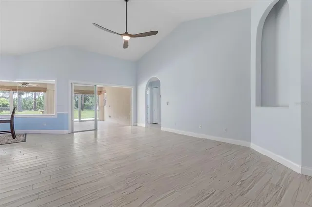 a view of a livingroom with wooden floor and a ceiling fan