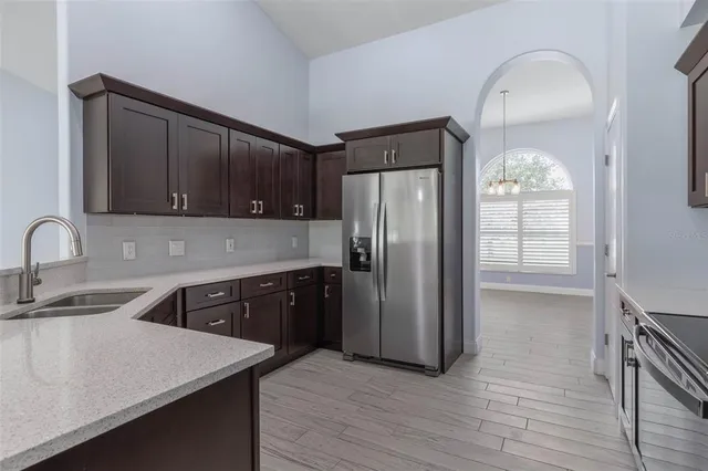 a kitchen with stainless steel appliances granite countertop a refrigerator a sink a stove and oven