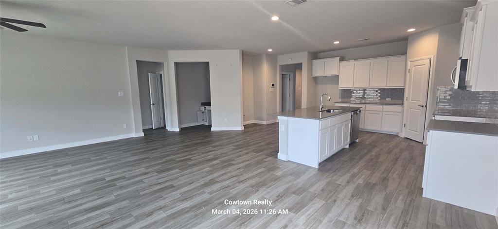 2340 Goodnight Ranch Drive Weatherford, TX 76087 - Photo 18 of 19 a large kitchen with cabinets wooden floor and stainless steel appliances
