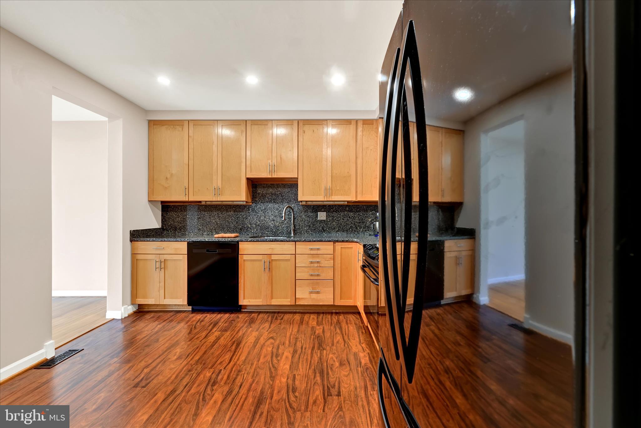 2317 Wonderview Road Lutherville-Timonium, MD 21093 - Photo 6 of 27 a kitchen with granite countertop wooden floors appliances and a sink