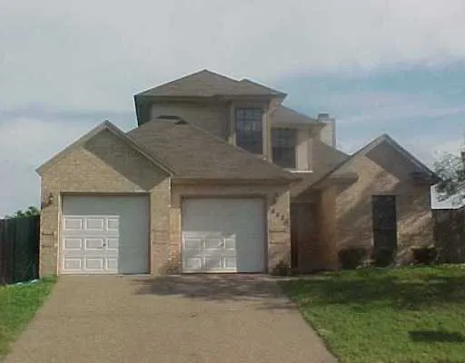 a front view of a house with a garden and yard