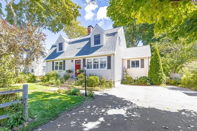 a front view of a house with a yard and trees