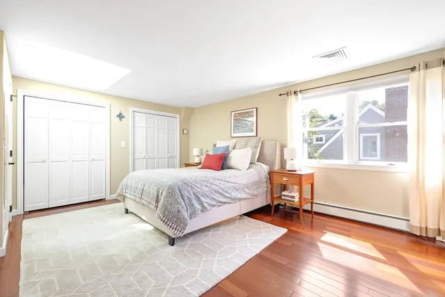 a spacious bedroom with a bed and wooden floor