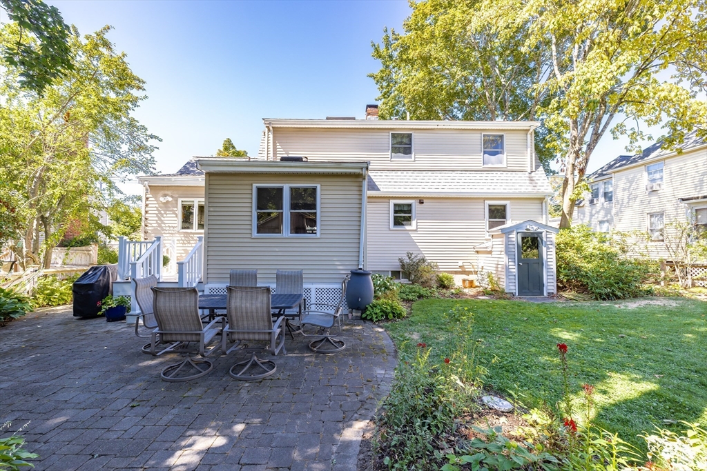 28 Cottage Street Natick, MA 01760 - Photo 28 of 32 a view of a patio with table and chairs potted plants and large tree