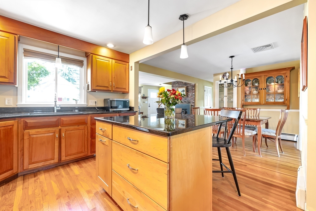 28 Cottage Street Natick, MA 01760 - Photo 7 of 32 a kitchen with stainless steel appliances granite countertop dining table chairs and wooden floor
