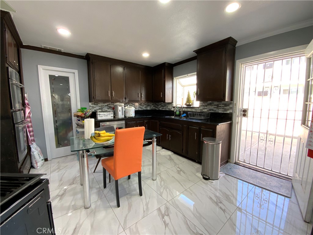 4131 Rowland Avenue El Monte, CA 91731 - Photo 6 of 22 a kitchen with a sink a stove a refrigerator and wooden cabinets