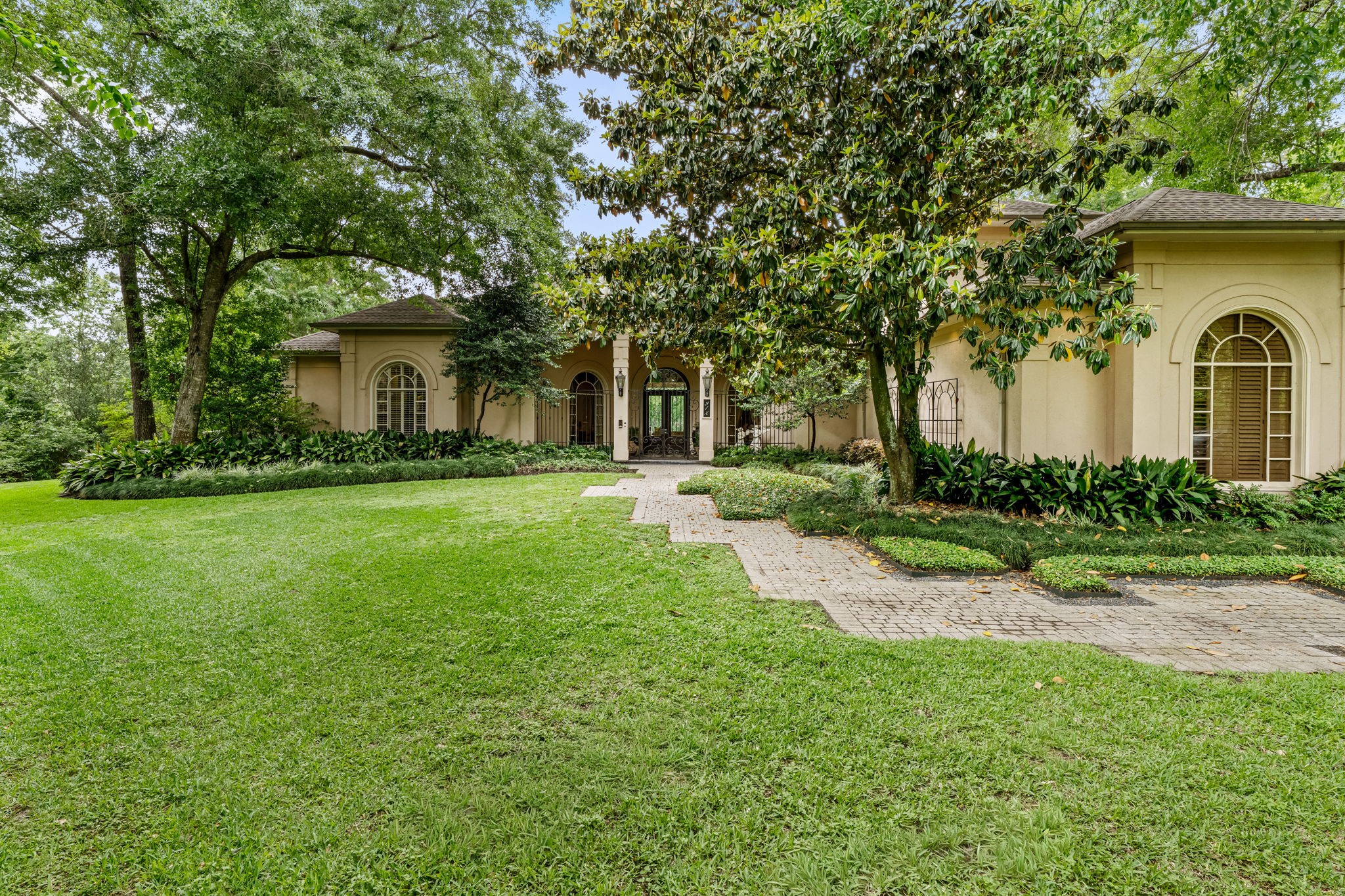 6 Mott Lane Houston, TX 77024 - Photo 6 of 50 Arched windows, stucco exterior and a gated entry create timeless curb appeal.
