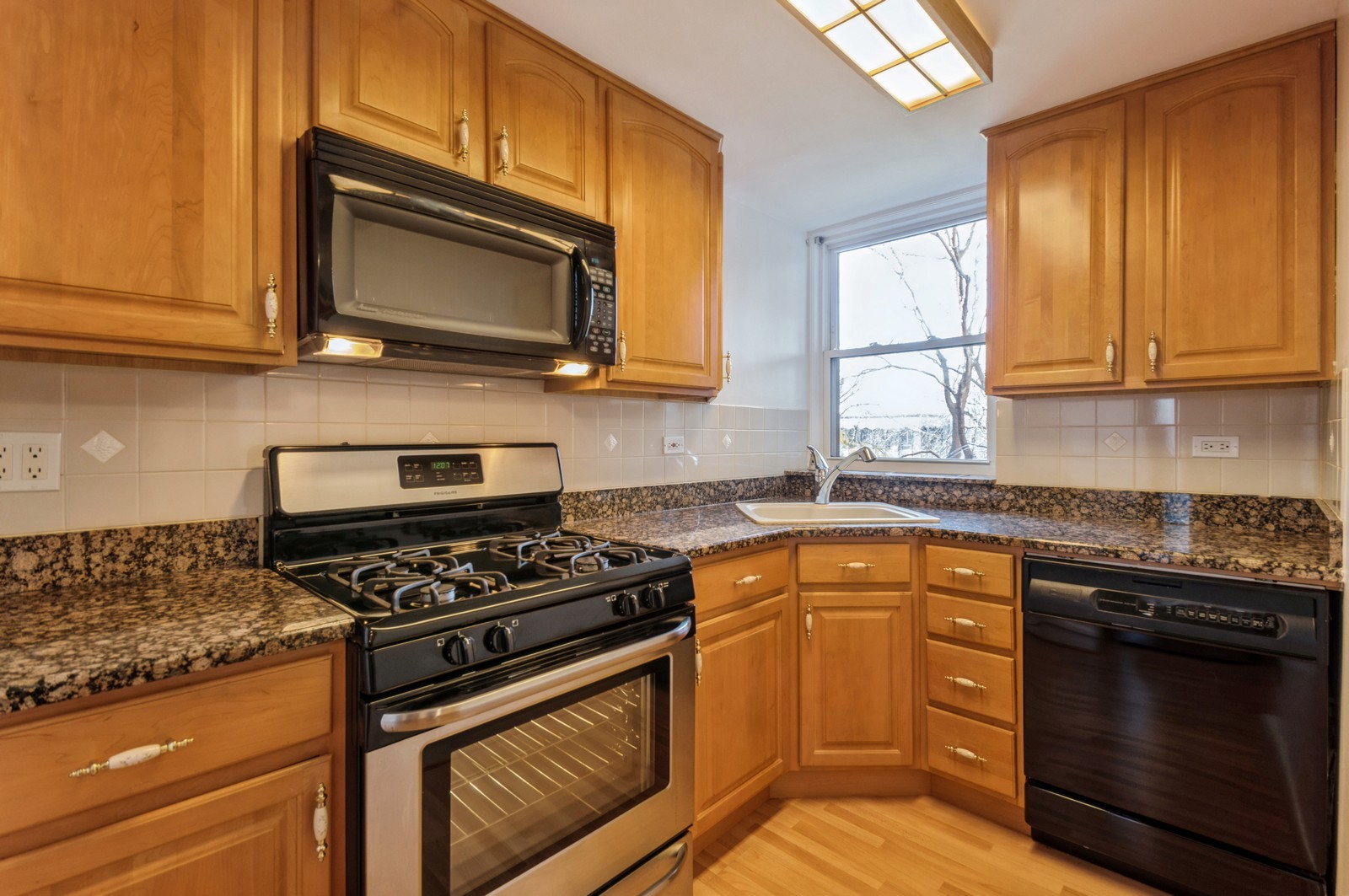 1585 Ridge Avenue, Unit 302 Evanston, IL 60201 - Photo 5 of 21 a kitchen with stainless steel appliances granite countertop a stove microwave and sink