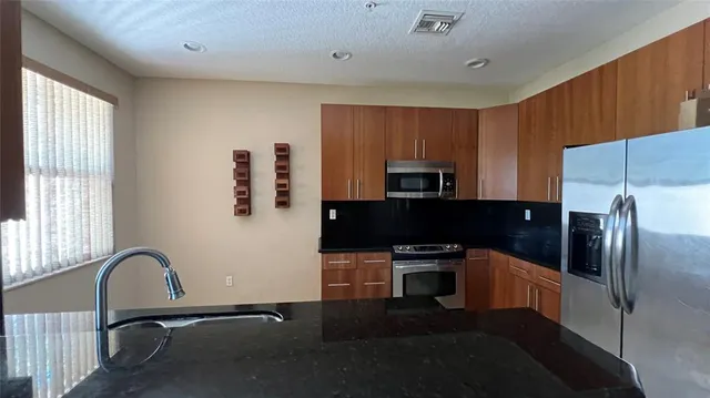 a kitchen with stainless steel appliances a refrigerator and a stove top oven