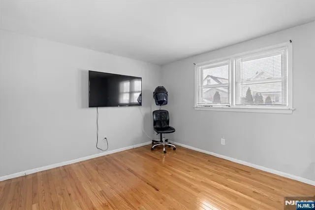 a view of a workspace with wooden floor and a window