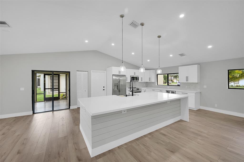 6195 Winding Brook Way Delray Beach, FL 33484 - Photo 15 of 68 a large white kitchen with a large window a oven and stainless steel appliances