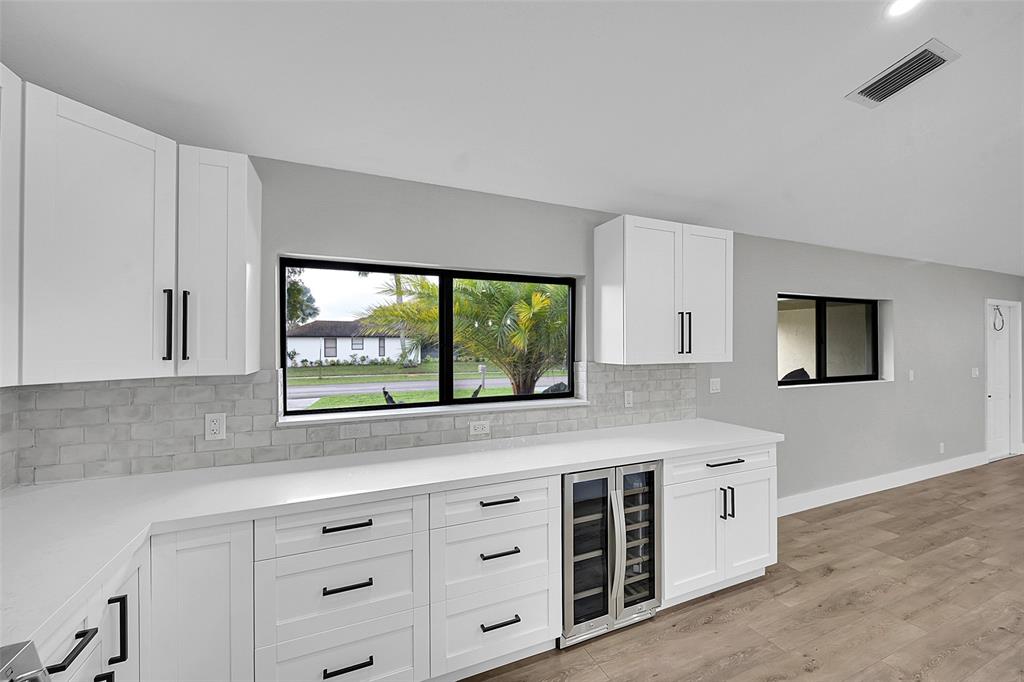 6195 Winding Brook Way Delray Beach, FL 33484 - Photo 18 of 68 a kitchen with stainless steel appliances white cabinets and a window