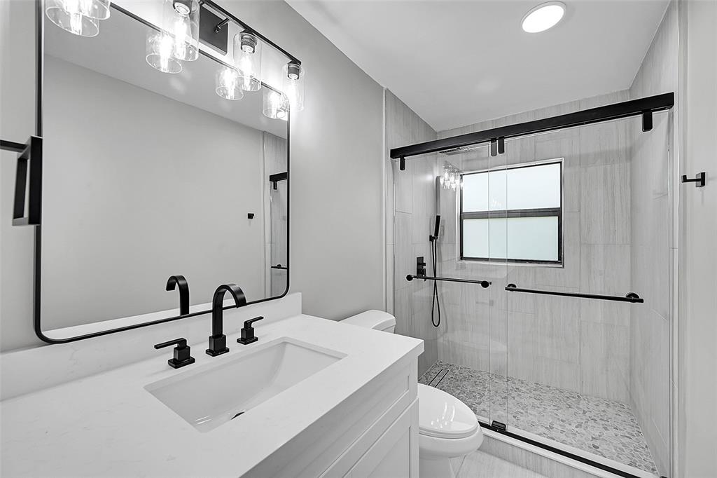 6195 Winding Brook Way Delray Beach, FL 33484 - Photo 35 of 68 a bathroom with a sink a toilet and shower