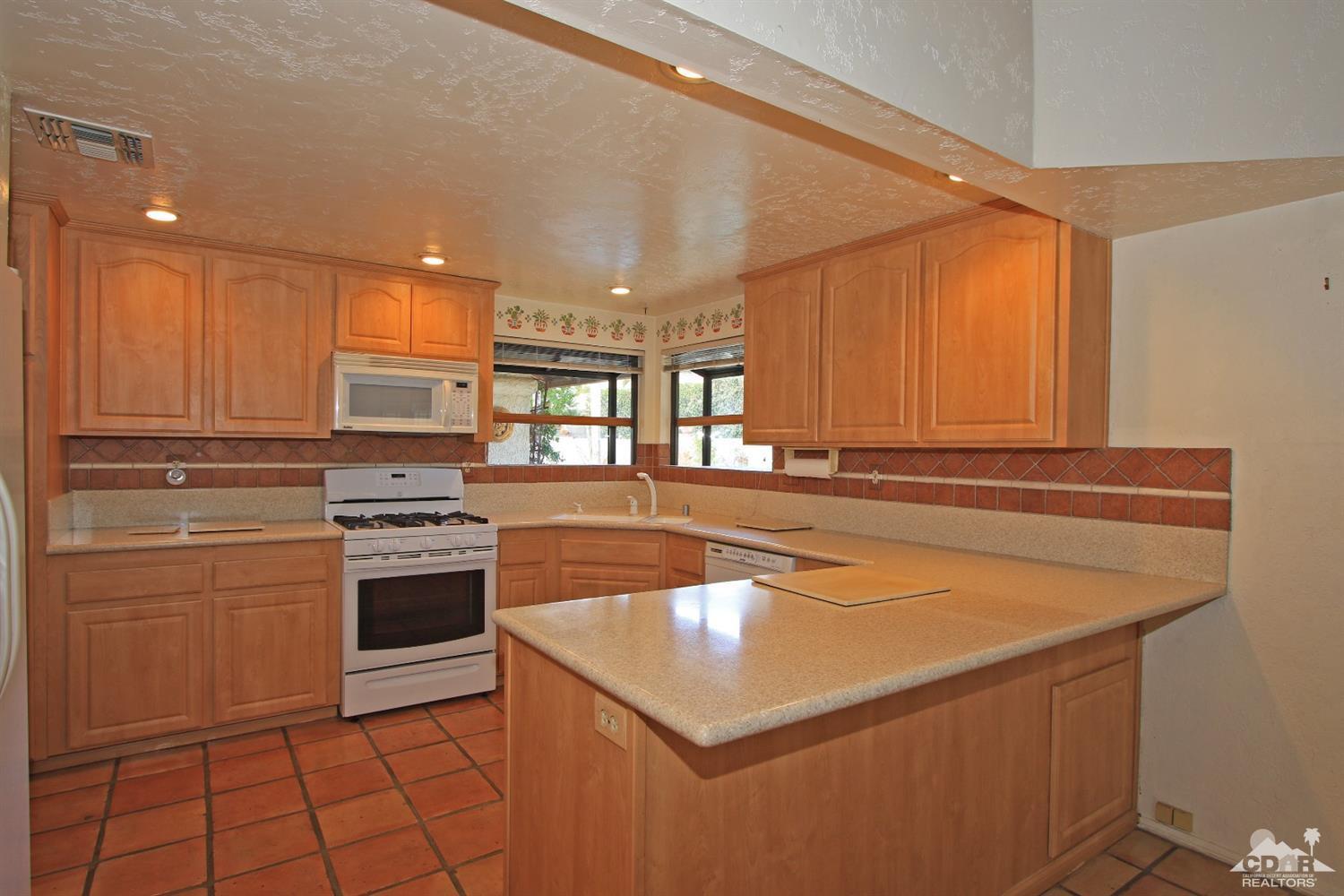 70400 Chappel Road Rancho Mirage, CA 92270 - Photo 20 of 49 a kitchen with stainless steel appliances granite countertop a sink and a stove