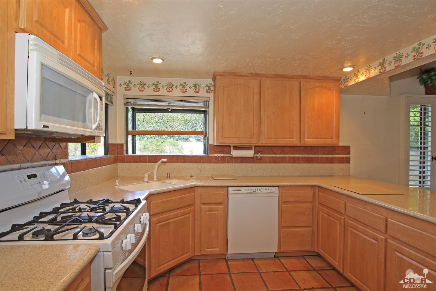 70400 Chappel Road Rancho Mirage, CA 92270 - Photo 21 of 49 a kitchen with a sink stove and cabinets