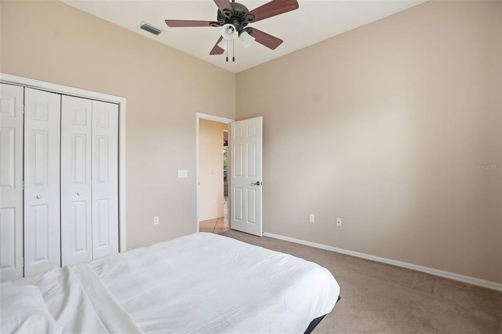 14228 Presteign Lane Spring Hill, FL 34609 - Photo 58 of 89 a bedroom with a bed and a chandelier fan