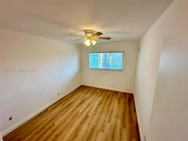 a view of an empty room and chandelier fan