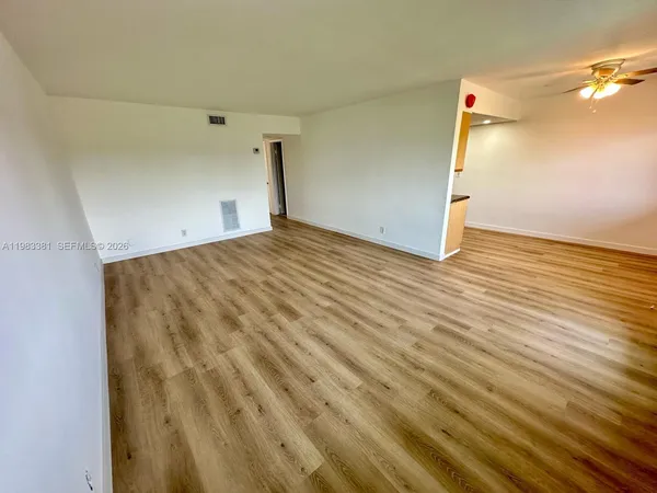 a view of empty room with wooden floor