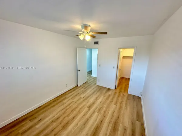 a view of empty room with wooden floor