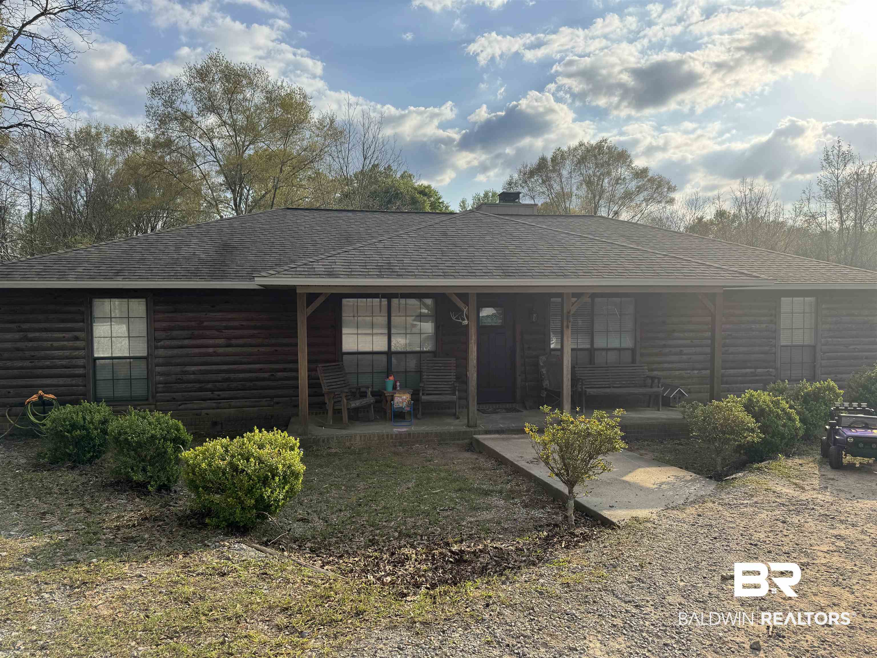 211 Kent Road Atmore, AL 36502 - Photo 1 of 1 Ranch-style home with roof with shingles, a porch, log veneer siding, and a chimney