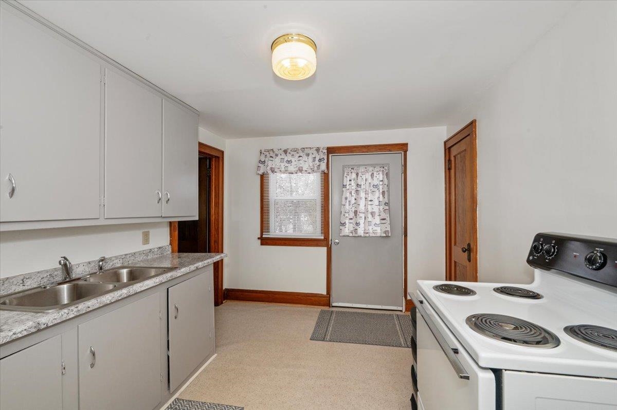 3729 East 2nd Street Superior, WI 54880 - Photo 11 of 20 Kitchen featuring electric range, baseboards, light countertops, and a sink