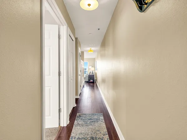 a view of a hallway with wooden floor and staircase